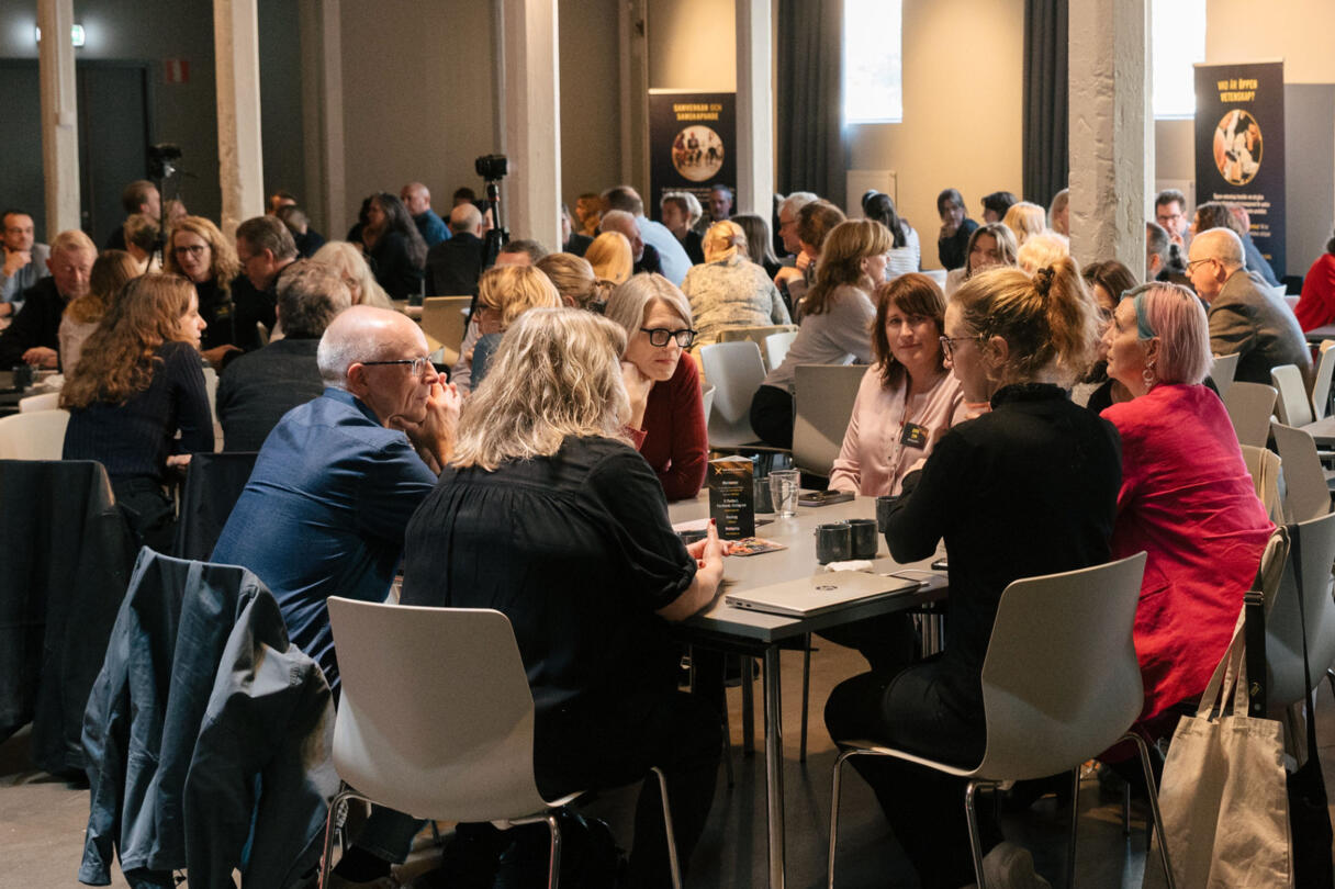 Personer i olika åldrar som diskuterar samhällsutmaningar och forskningen för evidensbaserade politiska beslut